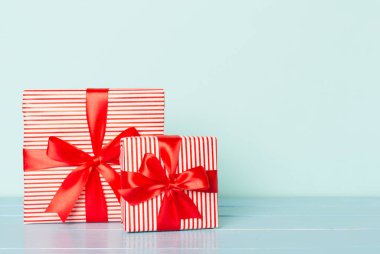 Arkaplanda kırmızı kurdele olan hediye kutuları.