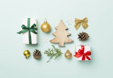 Renkli arka planda noel hediyeleri, oyuncaklar, ardıç ve koniler vardı..