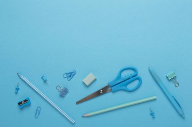 Düz yatıyordu mavi okul kırtasiyesiyle Renkli arka plan, üst görünüm