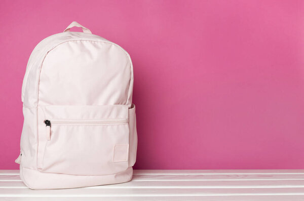 Рюкзак розовой школы на деревянном столе