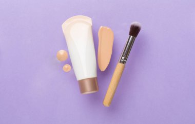 Renk arkaplanında makyaj temeli olan kompozisyon, üst görünüm