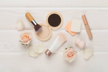 Ahşap arka planda cilt rengi için makyaj ürünleri bileşimi, üst görünüm