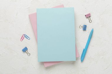 Beton zemin üzerinde kırtasiye malzemesi olan defterler, üst görünüm