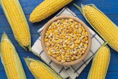 Kuru mısır ve ahşap arka planda taze koçanlar, üst manzara.