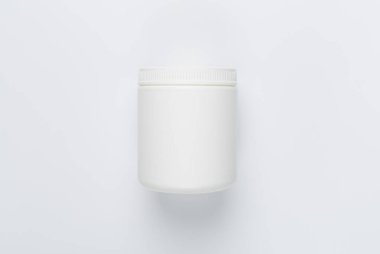 Beyaz zemin üzerinde vitaminler olan plastik şişe, üst görünüm