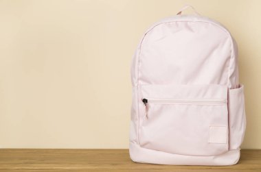 Beton masada pembe okul çantası.