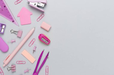 Renkli arka plan üzerine pembe okul kırtasiyesi, üst görünüm