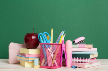 Ahşap masa üzerinde kitap ve kırtasiye malzemesi olan kompozisyon. Okul konseptine dönelim.