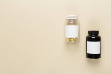 Renkli arka planda vitaminleri olan plastik şişeler, üst görünüm