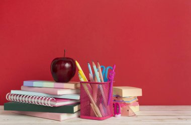 Ahşap masa üzerinde kitap ve kırtasiye malzemesi olan kompozisyon. Okul konseptine dönelim.