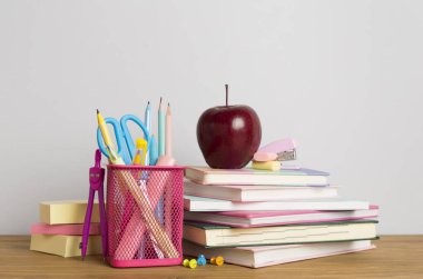 Ahşap masa üzerinde kitap ve kırtasiye malzemesi olan kompozisyon. Okul konseptine dönelim.