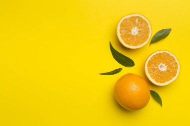 Flat lay with fresh oranges and leaves on color background.
