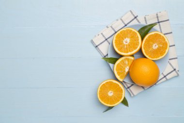 Flat lay with fresh oranges and leaves on wooden background.