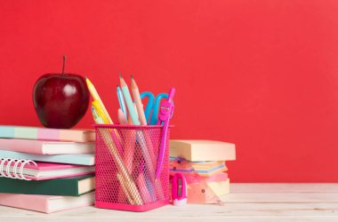 Ahşap masa üzerinde kitap ve kırtasiye malzemesi olan kompozisyon. Okul konseptine dönelim.