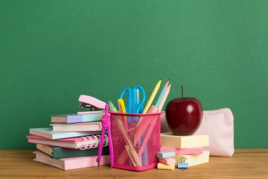 Ahşap masa üzerinde kitap ve kırtasiye malzemesi olan kompozisyon. Okul konseptine dönelim.