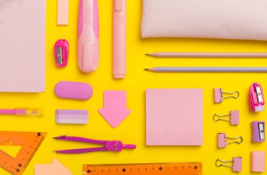 Renkli arka plan üzerinde pembe okul kırtasiyesi olan desen, üst görünüm