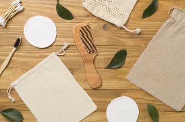 Flat lay with natural biodegradable accessories on wooden background, top view.