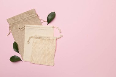 Small eco sacks with green leaves color on background. Top view.