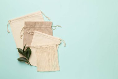 Small eco sacks with green leaves color on background. Top view