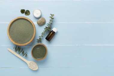 Ahşap arka planda kozmetik kil ve spa ürünleri ile kompozisyon, üst görünüm