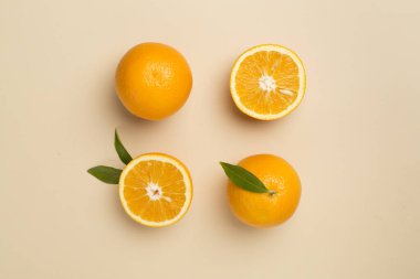 Flat lay with fresh oranges and leaves on color background.
