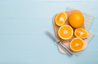 Flat lay with fresh oranges and leaves on wooden background.