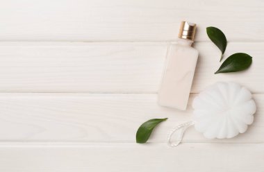 Shower gel with washcloth on wooden background, top view