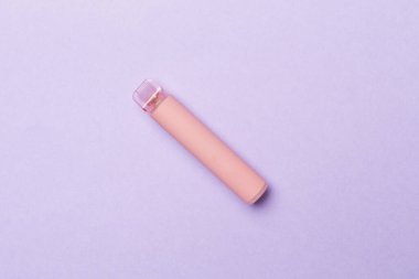 Disposable electronic cigarette on color background, top view