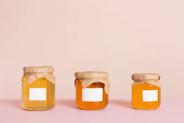 Jars with honey on color background. Mock up design
