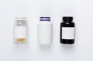 Beyaz arka planda vitaminleri olan plastik şişeler.