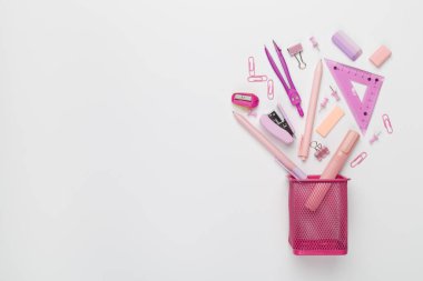 Renkli arka plan üzerinde okul kırtasiyesi olan pembe kalem tutucu, üst görünüm