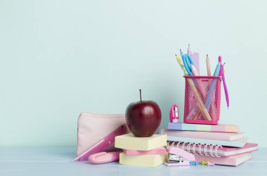 Ahşap masa üzerinde kitap ve kırtasiye malzemesi olan kompozisyon. Okul konseptine dönelim.