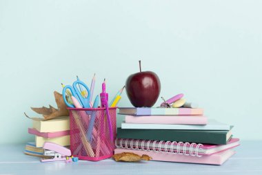 Ahşap masa üzerinde kitap ve kırtasiye malzemesi olan kompozisyon. Okul konseptine dönelim.