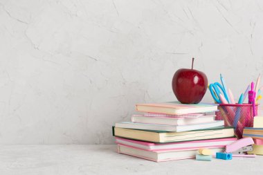 Ahşap masa üzerinde kitap ve kırtasiye malzemesi olan kompozisyon. Okul konseptine dönelim.