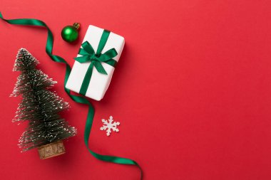 Arkaplanda hediye kutuları ve dekoru olan minyatür noel ağacı