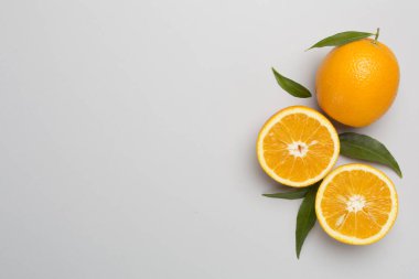 Beton zemin üzerinde yaprakları olan taze portakallar