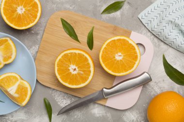 Beton zemin üzerinde yaprakları olan taze portakallar.