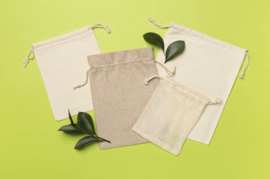 Small eco sacks with green leaves color on background. Top view