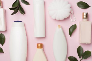 Renkli arka planda farklı kozmetik şişeler ve el bezi, üst görünüm