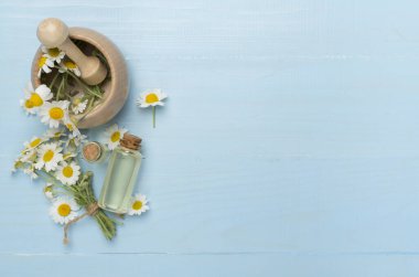 Ahşap arka planda gerekli yağ ve papatya çiçekleri ile kompozisyon, üst görünüm