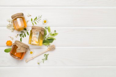 Ahşap zemin üzerinde farklı bal türleri olan kavanozlar, üst görünüm