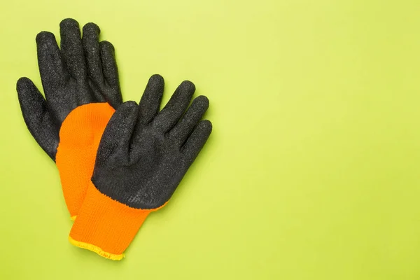 Garden gloves on color background, top view