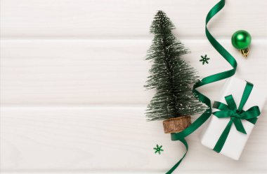 Minyatür Noel ağacı, hediye kutusu ve ahşap arka planda dekor.