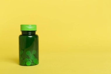 Renk arkaplanındaki vitaminler için plastik şişe