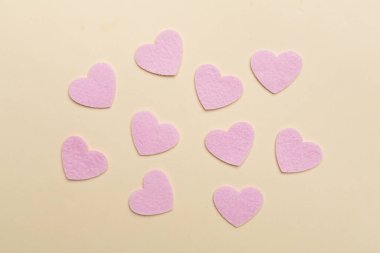 Felt hearts on color background, top view
