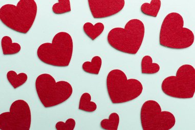 Felt hearts on color background, top view