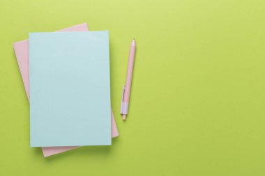 Renk arkaplanı ve üst görünümü üzerine kırtasiye içeren defter