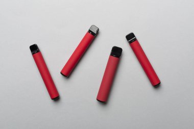 Disposable electronic cigarettes on color background, top view