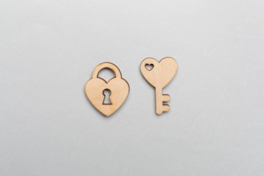 Wooden padlock with key on color background, top view