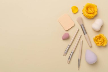 Renk arkaplanında makyaj fırçaları ve süngerler, üst görünüm